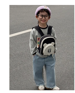 Toddler wearing a cute panda cartoon backpack with 3D ears during outdoor street walk