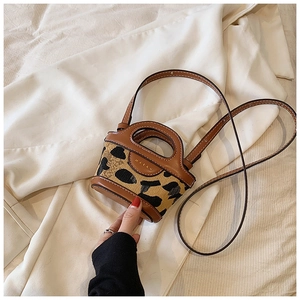 Mini leopard print crossbody bag with brown leather handles and adjustable strap detail
