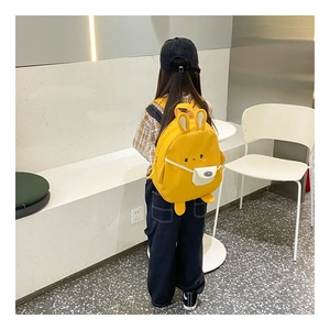 Detail eines gelben Kinderrucksacks aus Segeltuch mit niedlichen 3D-Hasenohren und Stoff