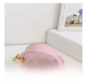 Close-up of pink quilted bucket bag with chain strap and luxury stitched leather detail