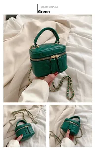 Detail view of a green quilted leather mini bag with gold chain strap and handle