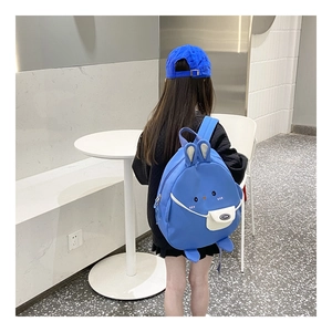 Blauer Kinderrucksack mit Hasenohren aus Leinwand, Seitenansicht an einem Kindermodel