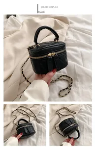 Detail of black quilted leather vanity bag with gold-tone hardware and chain strap