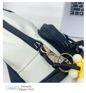 Gros plan d'une fermeture éclair noire lisse et d'un pendentif tressé sur un sac en toile
