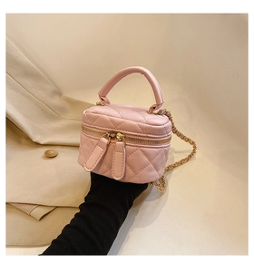 Detail of pink quilted leather mini cosmetic bag with gold chain and dual zipper closure