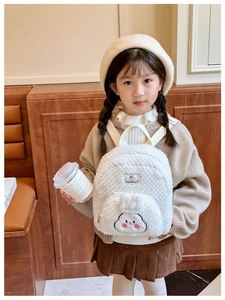 Close-up of white plush bunny backpack with 3D ears and cute facial embroidery details