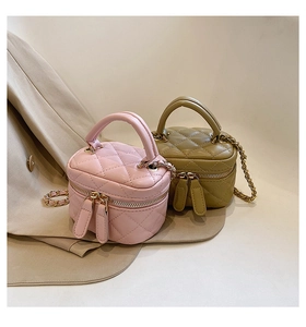 Detail of pink and olive green quilted mini vanity bags with gold chain straps and dual zippers