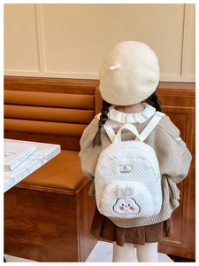 Detail of cute white plush rabbit backpack for toddlers with soft lamb wool texture