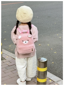 Close-up of cute pink plush bear backpack showing soft fuzzy texture and strap details