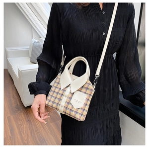 Close-up of contrast plaid shirt-shaped crossbody bag with button detail and leather strap