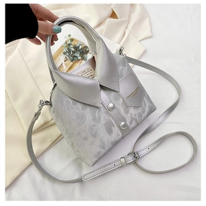 Detailed view of creative silver shirt-style bucket bag with collar and button accents