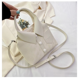 Detail of creative white shirt shaped bucket bag with collar, buttons, and shoulder strap