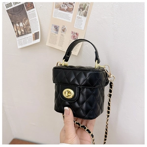 Close-up of black quilted mini bucket bag with gold clasp and leather chain strap
