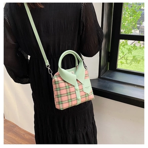Detail view of plaid crossbody bag with creative collar design and tweed texture