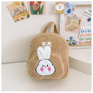 Close-up of fluffy brown teddy fleece kids backpack with white 3D bunny face and logo