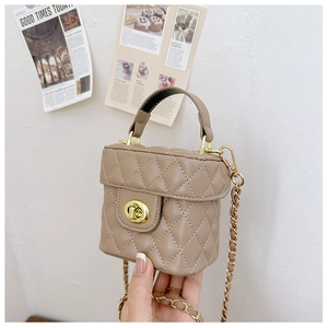 Detailed macro view of khaki quilted mini bucket bag with gold clasp and chain strap
