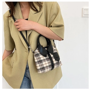 Detail of plaid handbag featuring unique shirt collar design and black leather trim accents