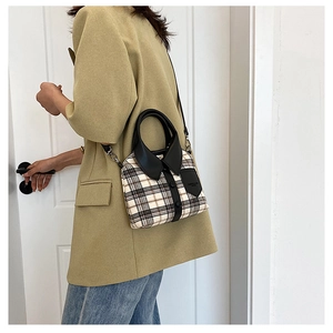 Detail of a plaid crossbody bag with shirt collar design and button accents