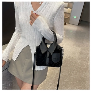 Detail of creative shirt-shaped black bucket bag with fashion lettering and velvet texture