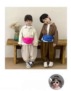 Close-up of vibrant pink and blue canvas waist bags with colorful braided pullers for kids