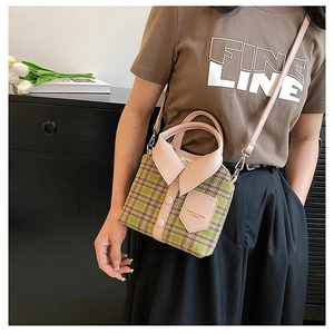 Detail view of a creative shirt-shaped crossbody bag with green plaid and pink leather trim