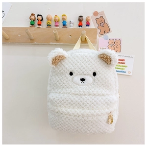 Detailed view of white plush kid's backpack with cute bear embroidery and teddy fleece texture