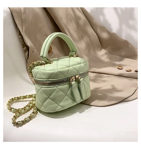 Detail of mint green quilted mini vanity bag with leather-chain strap and gold hardware