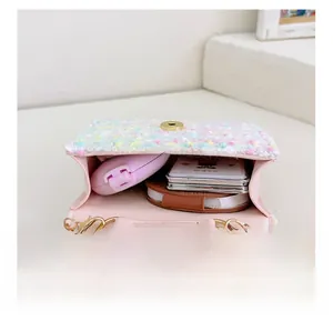 Detail view of pink mini crossbody bag interior showing storage for makeup and cards