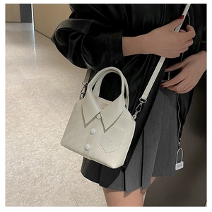 Detail of white shirt-style bucket bag with collar design and silver chain strap