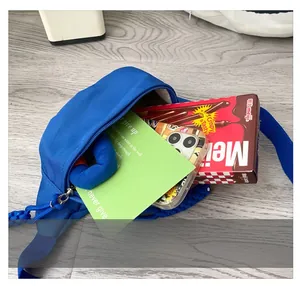 Detail shot of blue canvas waist bag interior capacity showing phone and snacks