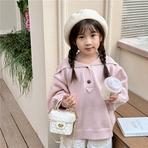 Pink knit sweater and white quilted chain bucket bag for girls in a soft outdoor setting