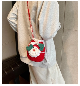 Detail of handmade crochet Santa Claus drawstring bag with red and white braided strap
