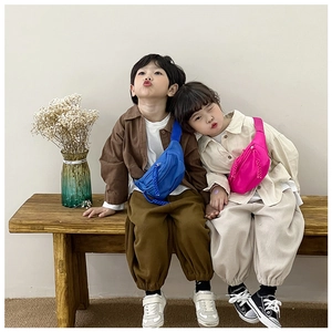 Detail of colorful nylon kids chest bags in blue and pink with adjustable woven straps
