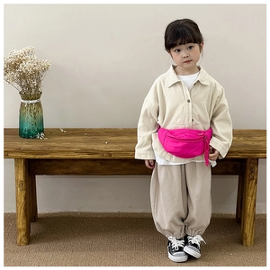 Detail of macaron pink nylon chest bag for kids with tone-on-tone braided zipper pull