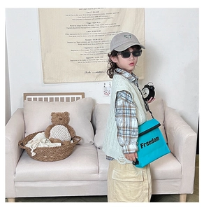 Close-up of vibrant blue crossbody bag with Freedom text for child's casual outfit