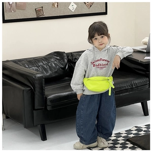 Detailed close-up of a neon yellow nylon kids waist bag with a woven rope zipper pull