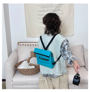 Detailed back view of a teal dual-use kids backpack featuring black Freedom lettering