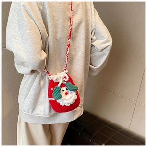 Detail of handmade crochet Santa Claus crossbody bag with red knit strap and 3D beard