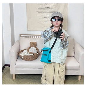 Close-up of blue nylon crossbody bag with Freedom logo on a boy in stylish outfit