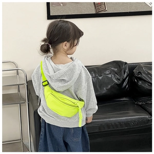 Close-up of neon green kids waist bag with adjustable strap worn by a toddler