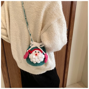 Detail of handmade crochet Christmas Santa bag with 3D beard and green woven strap