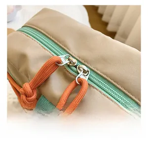 Close-up of smooth green zipper and orange woven rope pull on kids nylon crossbody bag