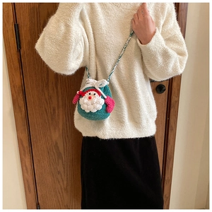 Detailed handmade crochet Santa Claus bag with festive red hat and green yarn texture