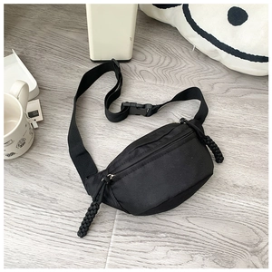 Detail of black nylon kids waist bag with braided zip puller and adjustable strap