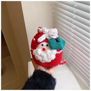 Detail of handmade crochet Santa drawstring bag with textured knit and heart charm