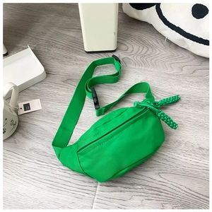 Macro detail of vibrant green nylon kids chest bag with woven rope zipper pulls