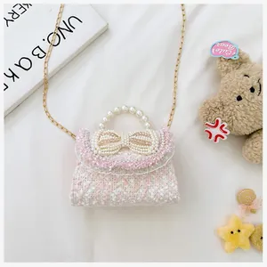 Detail of pink and white tweed kids handbag with large pearl bow and elegant lace trim