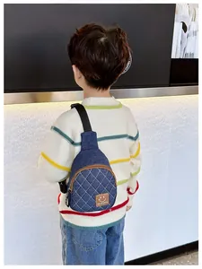 Dettaglio borsa a tracolla in denim per bambini con trapuntatura e toppa smile