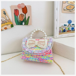 Close-up of colorful tweed kids bag with large pearl bow and lace ruffle edge detail