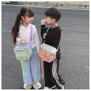 Outdoor shot of kids wearing canvas crossbody bags with neon rope accents and bear logo